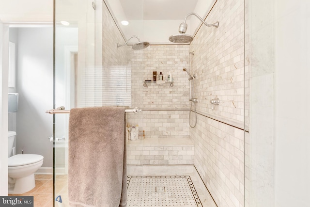 bathroom featuring tile patterned floors, a shower with shower door, and toilet