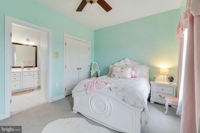 carpeted bedroom with ceiling fan, sink, connected bathroom, and a closet