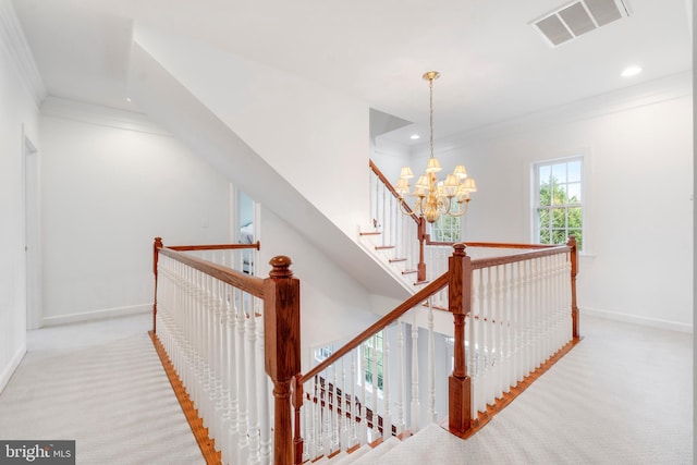 hallway with carpet, ornamental molding, and a notable chandelier