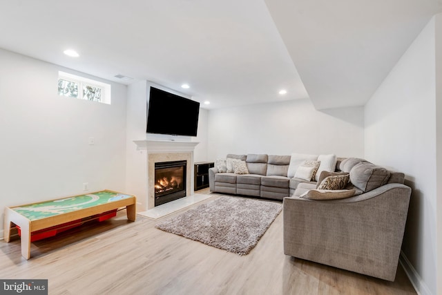 living room featuring a high end fireplace and hardwood / wood-style flooring