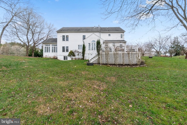 rear view of house featuring a yard and a wooden deck