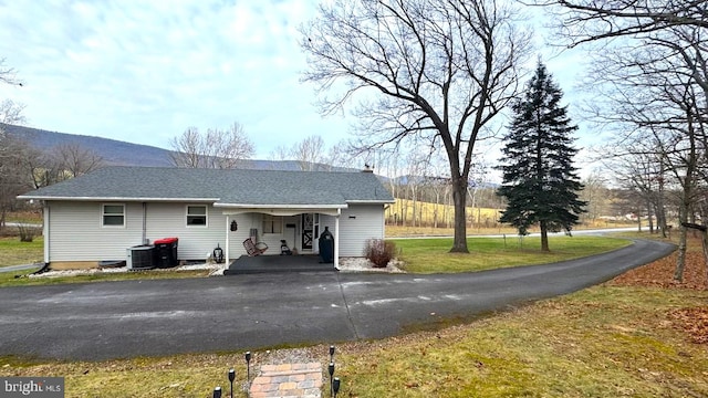 back of property featuring a lawn, a mountain view, and central air condition unit