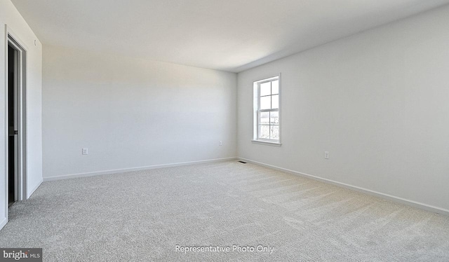 unfurnished room with light colored carpet