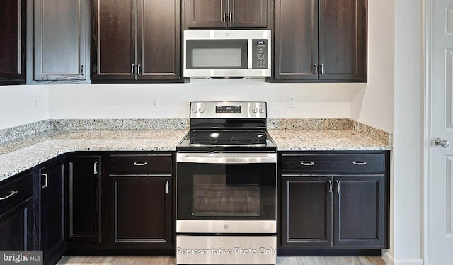 kitchen with dark brown cabinetry, light hardwood / wood-style flooring, and stainless steel appliances