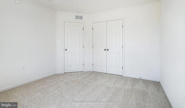 unfurnished bedroom featuring carpet flooring and a closet