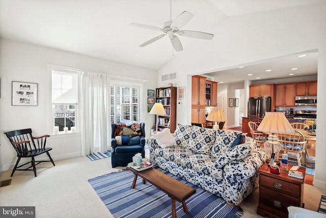 carpeted living room featuring ceiling fan and vaulted ceiling