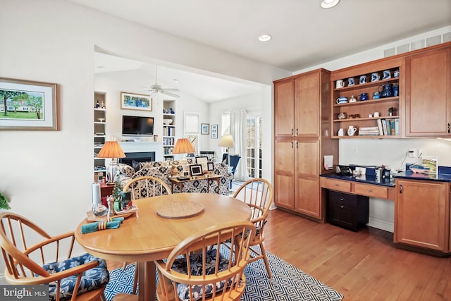 dining area with ceiling fan, wood-type flooring, and vaulted ceiling