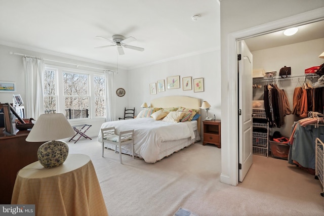 carpeted bedroom featuring ceiling fan, ornamental molding, and a closet