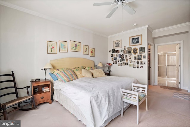 bedroom featuring ceiling fan, light colored carpet, ornamental molding, and ensuite bath