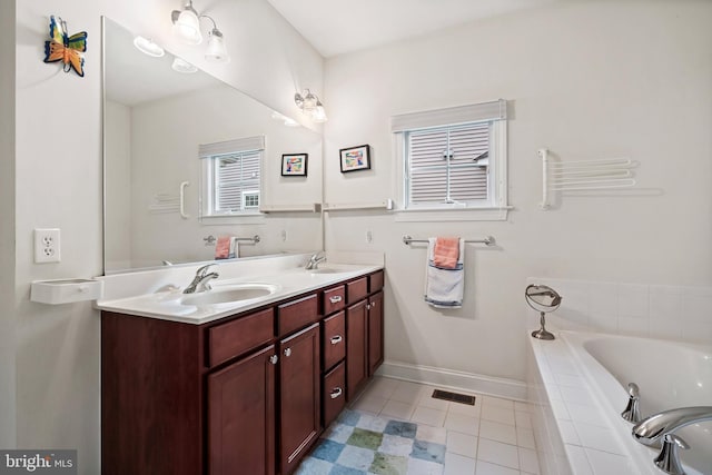 bathroom featuring tile patterned floors, vanity, and tiled tub