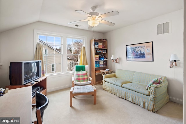 carpeted living room with ceiling fan and vaulted ceiling