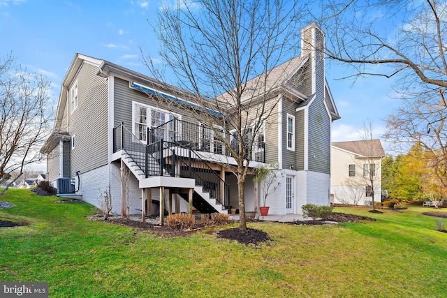 rear view of property featuring a yard, a patio, and central AC