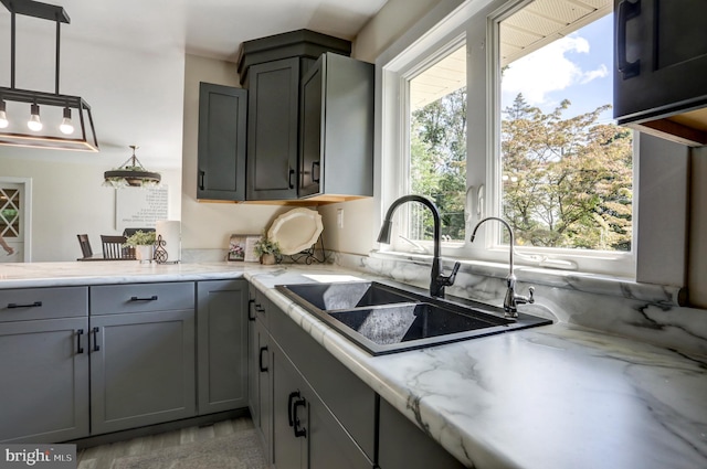 kitchen with plenty of natural light, gray cabinets, and sink