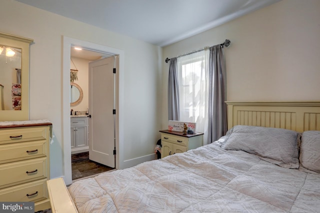 bedroom featuring ensuite bath and light hardwood / wood-style floors