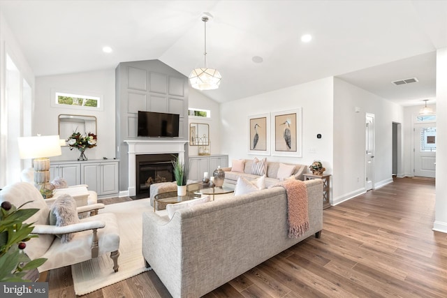 living room featuring a large fireplace, hardwood / wood-style flooring, and lofted ceiling