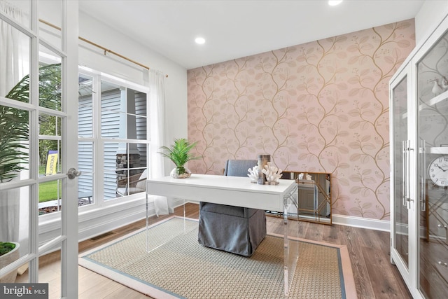 home office with hardwood / wood-style flooring, a healthy amount of sunlight, and french doors