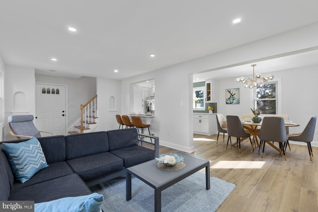 living room featuring a notable chandelier and light hardwood / wood-style floors