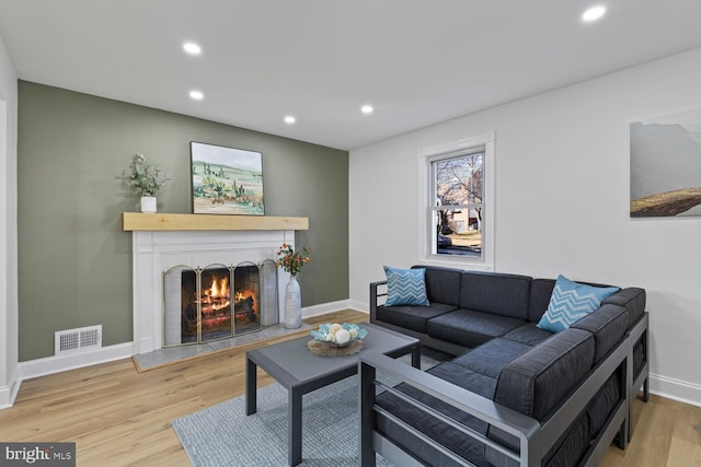 living room featuring light hardwood / wood-style floors and a brick fireplace