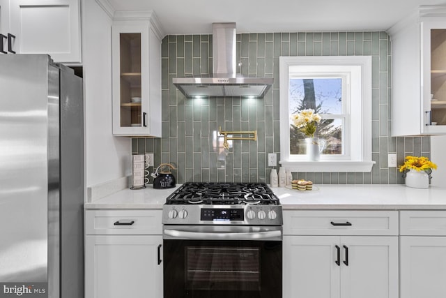 kitchen with white cabinets, wall chimney exhaust hood, and stainless steel appliances