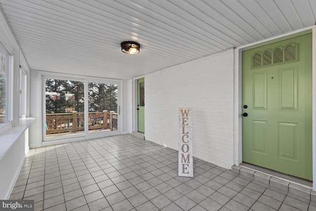 unfurnished sunroom featuring wood ceiling