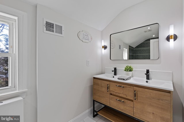 bathroom featuring tile patterned floors, vanity, and vaulted ceiling