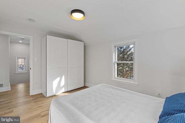 bedroom with light hardwood / wood-style flooring and vaulted ceiling