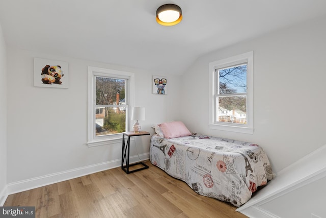 bedroom featuring light hardwood / wood-style flooring and lofted ceiling