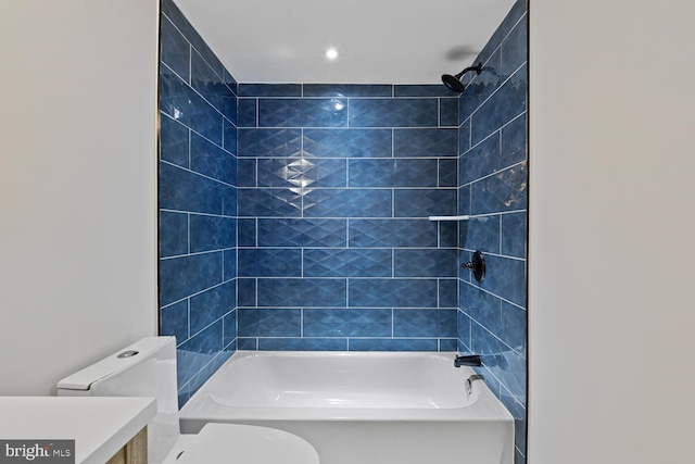 full bathroom with tiled shower / bath combo, toilet, and vanity