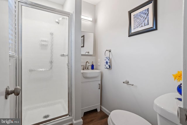 bathroom with vanity, toilet, a shower with door, and wood-type flooring