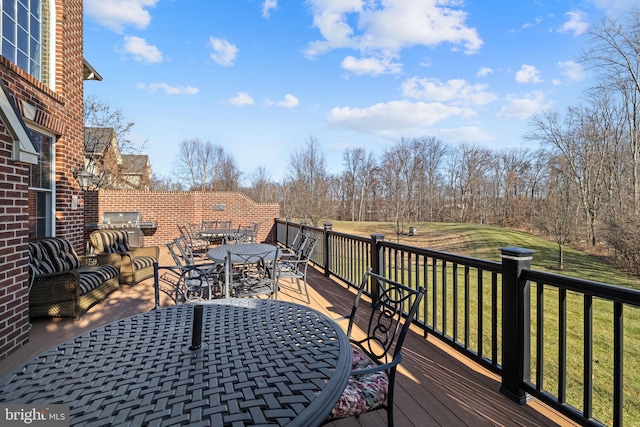 wooden terrace featuring a grill and a yard