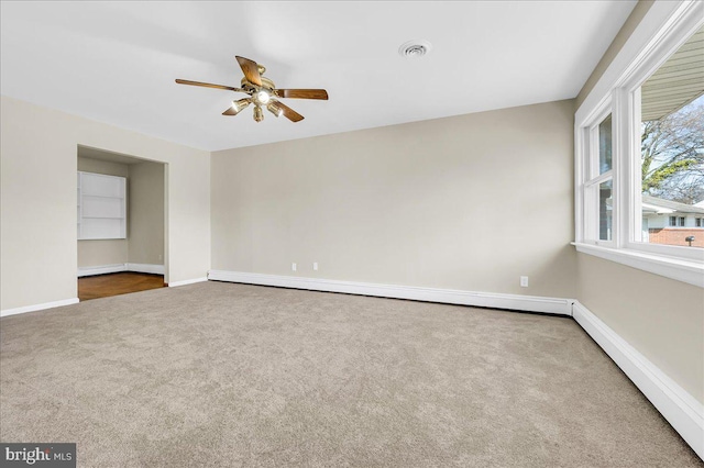 unfurnished room with ceiling fan, carpet floors, and a baseboard heating unit