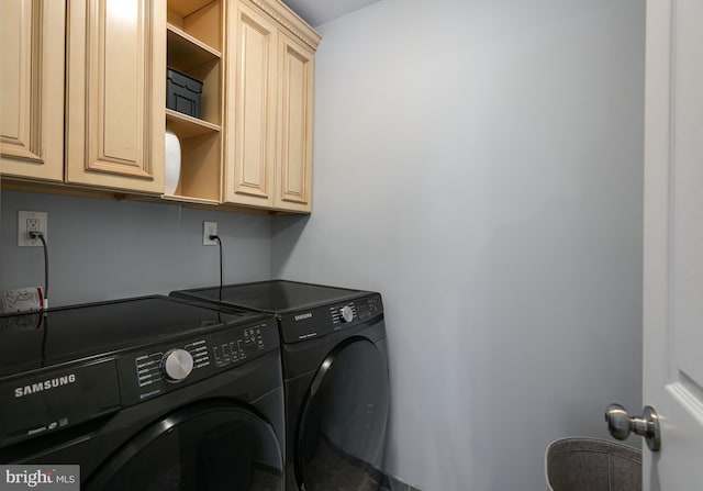 washroom with cabinets and washer and clothes dryer