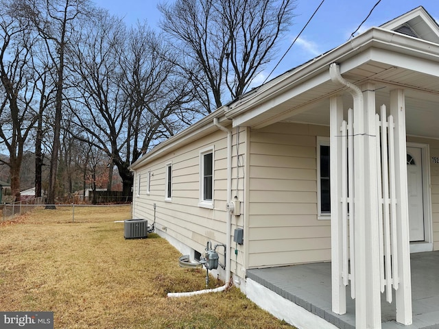 view of property exterior featuring central air condition unit and a lawn