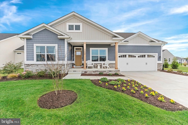 craftsman-style home featuring a garage, covered porch, and a front lawn