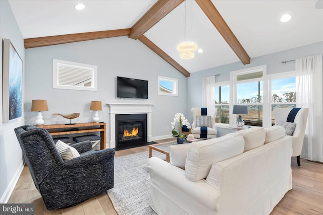 living room featuring lofted ceiling with beams and light hardwood / wood-style flooring