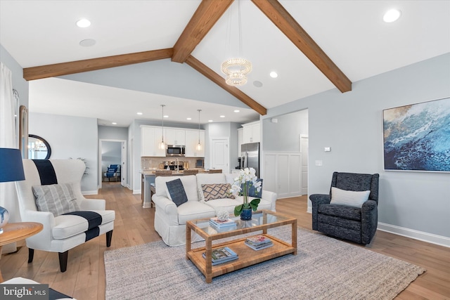 living room with a chandelier, light wood-type flooring, and lofted ceiling with beams