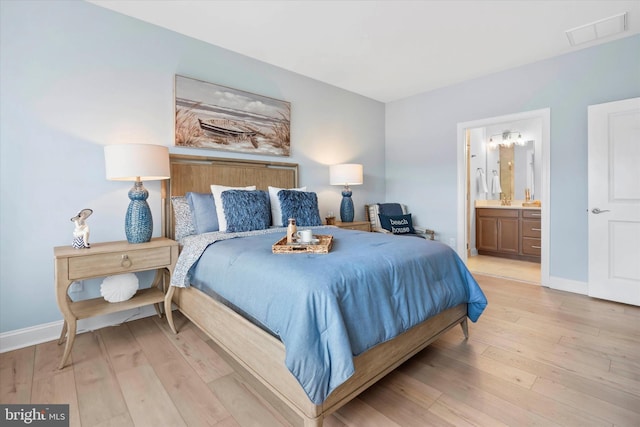 bedroom featuring ensuite bathroom and light hardwood / wood-style floors