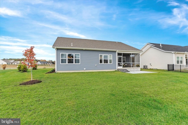 rear view of house featuring a sunroom, cooling unit, a patio, and a lawn