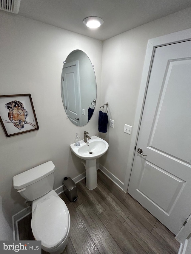 bathroom featuring hardwood / wood-style floors and toilet