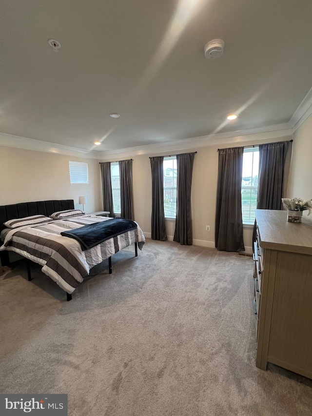 bedroom with multiple windows, crown molding, and light colored carpet