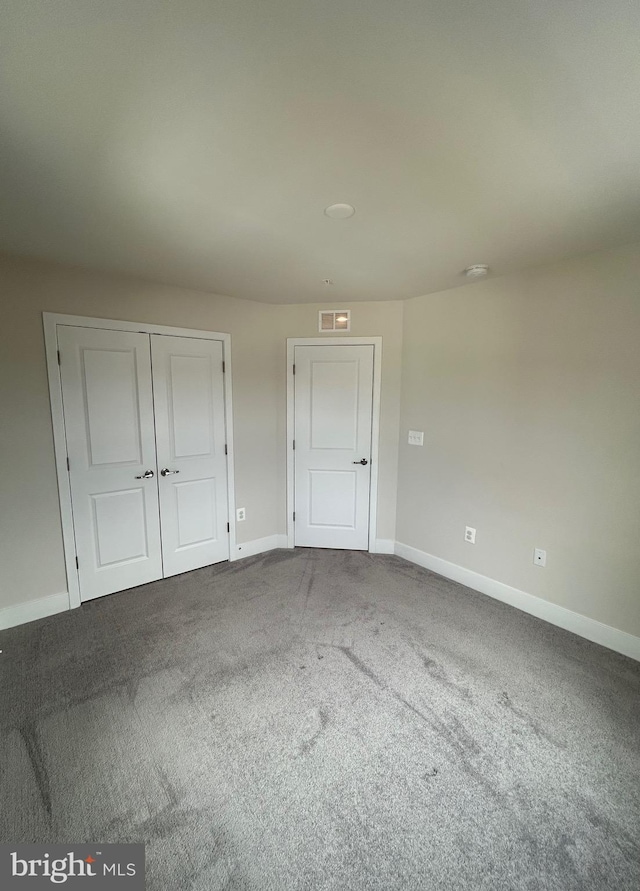 unfurnished bedroom featuring carpet flooring and a closet