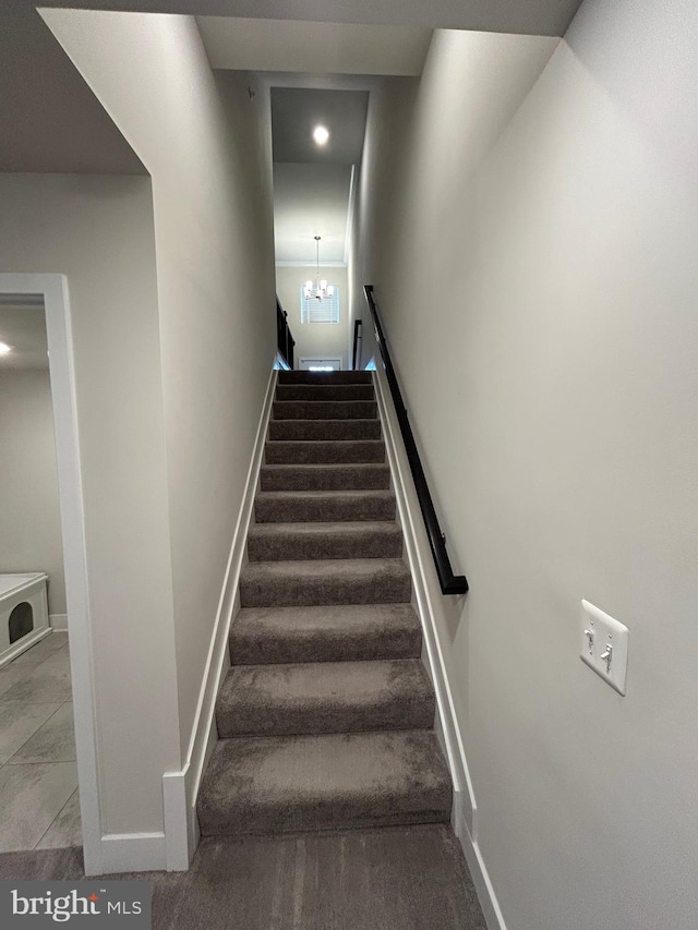 stairs featuring carpet and an inviting chandelier