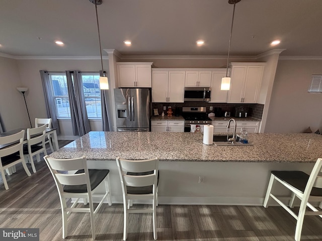 kitchen with decorative light fixtures, white cabinetry, backsplash, and appliances with stainless steel finishes