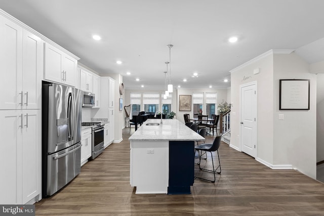 kitchen with a kitchen island with sink, white cabinets, light stone countertops, and appliances with stainless steel finishes