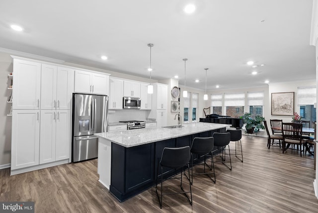 kitchen with a center island with sink, white cabinetry, sink, and appliances with stainless steel finishes