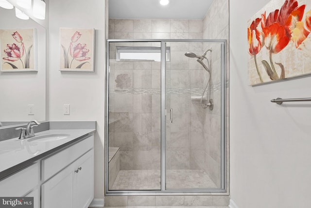 bathroom featuring vanity and a shower with door