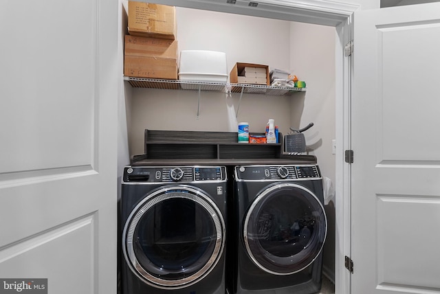 clothes washing area with washing machine and dryer