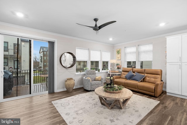 living room featuring dark hardwood / wood-style floors, a wealth of natural light, and ornamental molding