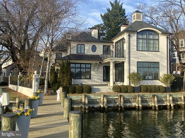 back of property featuring a water view and a balcony