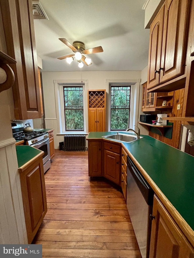 kitchen featuring radiator, a wealth of natural light, light hardwood / wood-style flooring, and stainless steel appliances